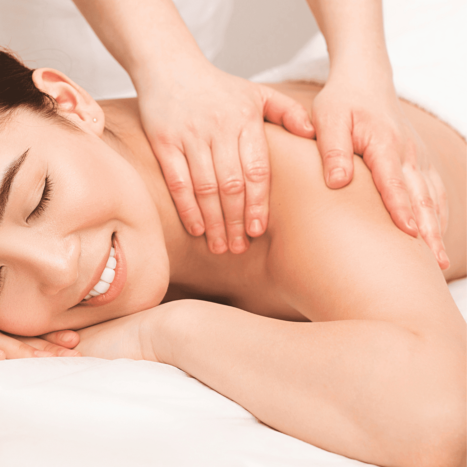 Person receiving a relaxing back massage, eyes closed, smiling.