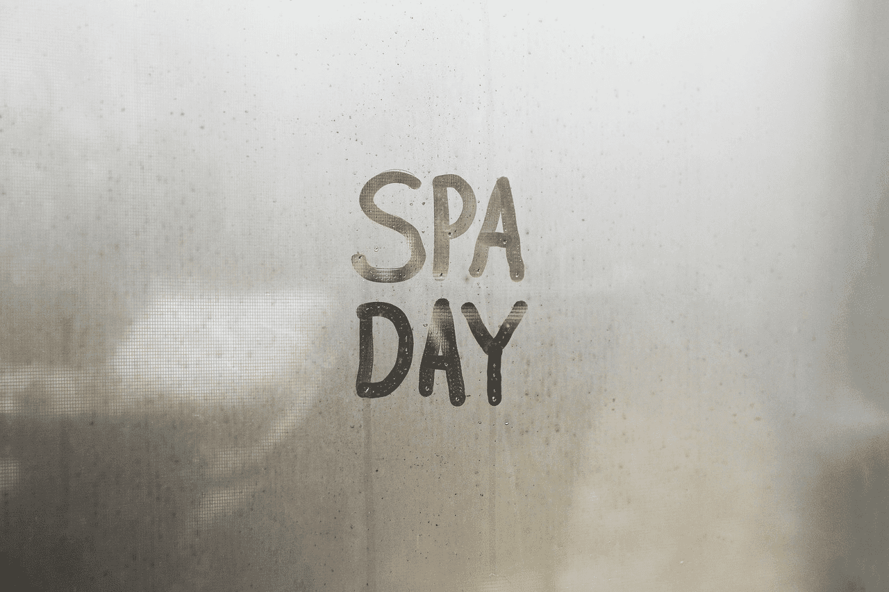 Foggy window with 'SPA DAY' written on it, evoking a relaxing atmosphere.