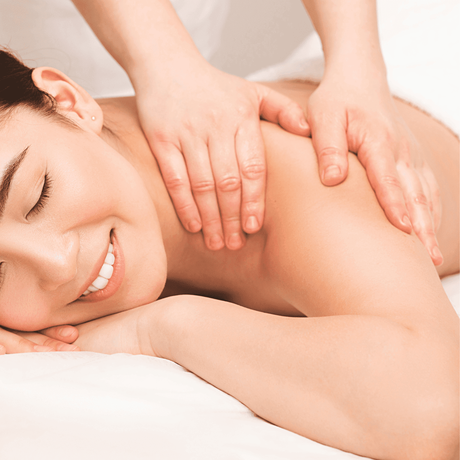 Person receiving a relaxing back massage, eyes closed, smiling.