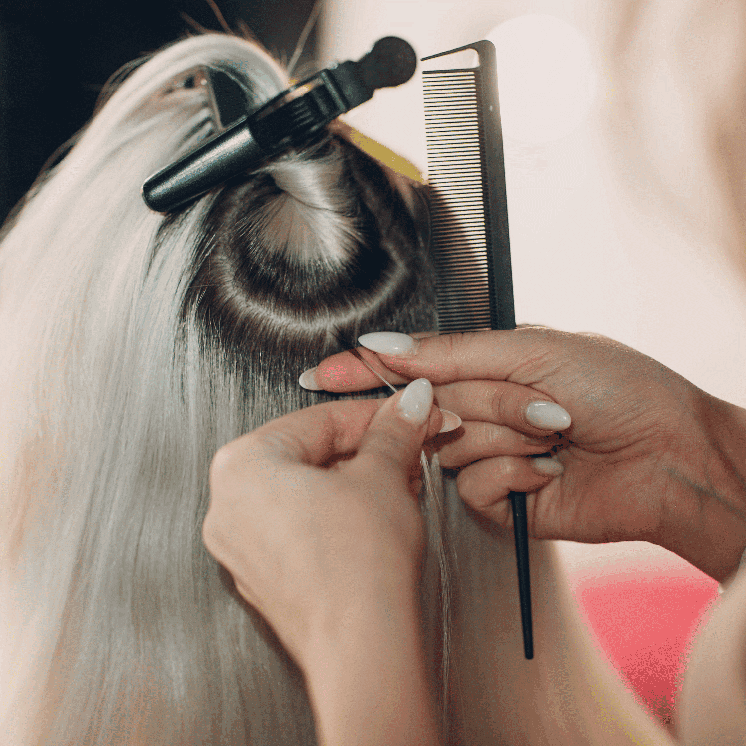 Hairdresser parting and preparing hair for styling.